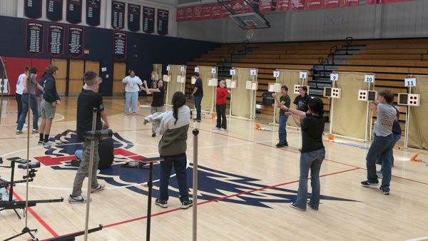 Coaches Sahi Weiser and Angus Babcock leading the campers through a series of stretches designed to relieve the muscles of tension before competing or practing for Air Rifle.